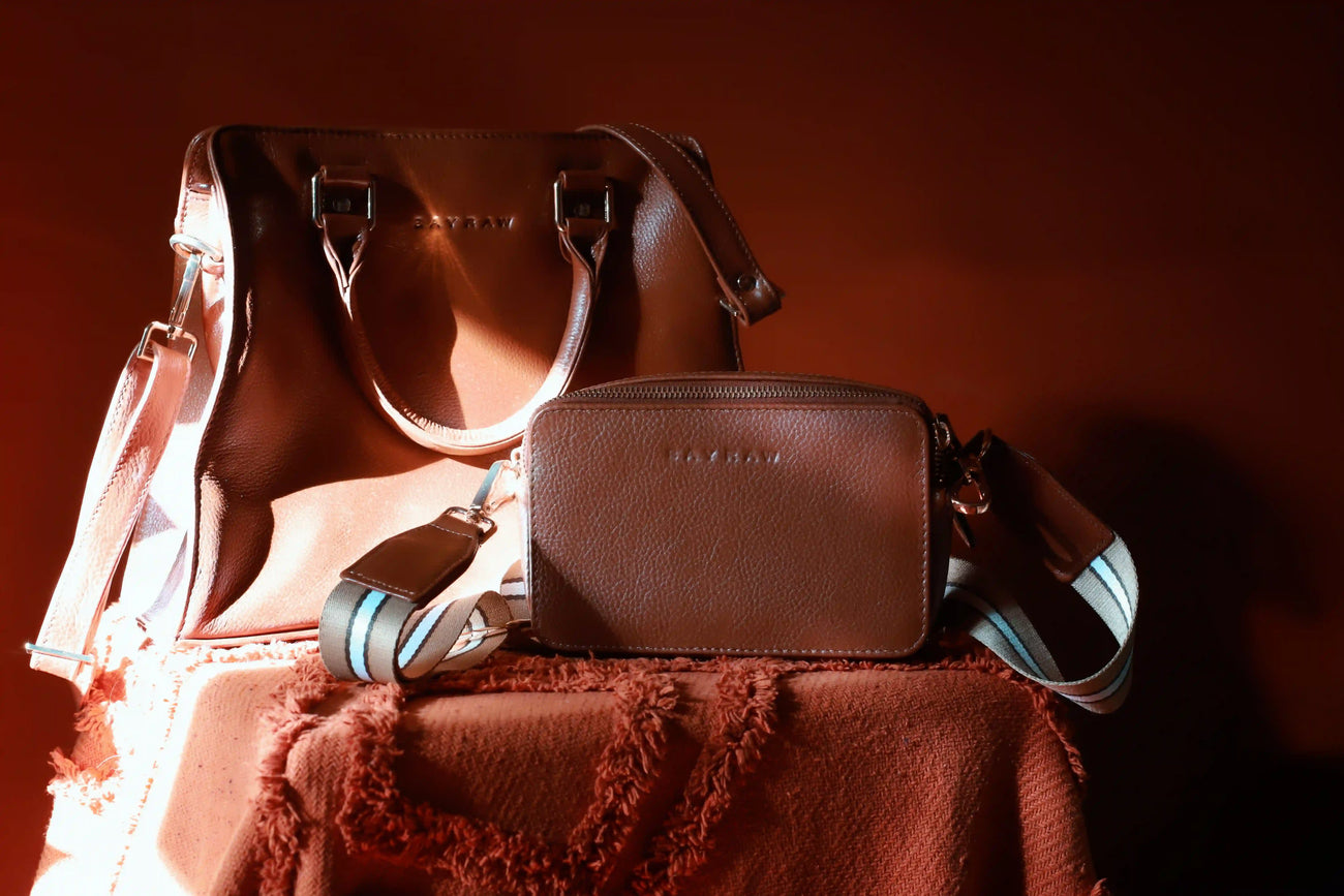 A leather bag being cared for gently